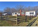 Classic home featuring a brick chimney and white siding, framed by a rustic fence and mature trees at 1426 E Council St, Salisbury, NC 28146