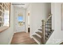 Bright entryway features hardwood floors, a glass pane front door and stairway at 1529 Pebble Shore Ln # 164, Belmont, NC 28012