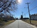 Quiet street view showcasing neighborhood charm with mature trees, clear skies, and community buildings at 2312 Bancroft St, Charlotte, NC 28206
