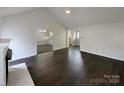 Open-concept living room with wood floors and a view of the kitchen at 3632 Farm Lake Sw Dr, Concord, NC 28027
