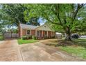 Charming brick home with lush green lawn and mature trees offering shade and curb appeal at 3714 Conway Ave, Charlotte, NC 28209