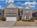A beautiful two-story brick house, featuring a two-car garage and manicured front lawn for a welcoming entrance at 4856 Pepper Dr, Harrisburg, NC 28075