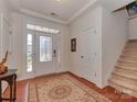 Welcoming foyer with hardwood floors, decorative rug, and staircase at 4856 Pepper Dr, Harrisburg, NC 28075