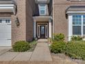 Elegant front door and walkway leading to the entrance, enhanced by brick detailing and trimmed landscaping at 4856 Pepper Dr, Harrisburg, NC 28075