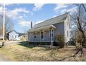 Quaint home featuring a covered front porch, charming architectural details, and mature trees at 520 Rogers St, Albemarle, NC 28001