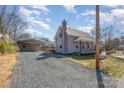 View of the house with gravel driveway and detached carport, blending convenience and charm at 520 Rogers St, Albemarle, NC 28001