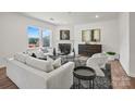 Bright living room features large windows, modern fireplace, neutral-toned furniture, and stylish decor at 5227 Hatcher Creek Rd # 43, Charlotte, NC 28215