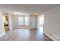 Sun-lit living area with wood-look laminate flooring, neutral walls, and a view of the front entrance at 5921 Amity Springs Dr, Charlotte, NC 28212