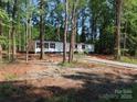 Wooded lot featuring a cozy single-story home with a freshly paved driveway at 635 Acre Ct, York, SC 29745