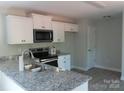 Well-equipped kitchen with granite countertops, stainless steel appliances, and sleek white cabinetry at 635 Acre Ct, York, SC 29745