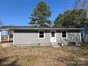 Backyard view of the gray house; features a door and windows overlooking the green lawn at 811 Sanford St, Marshville, NC 28103