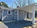 The gray house features white trim around the windows and on the carport's pillars at 811 Sanford St, Marshville, NC 28103