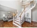 Bright foyer with hardwood floors, staircase and view to living room at 9627 Baileywick Rd, Charlotte, NC 28277