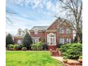 Elegant two-story brick home with manicured lawn and charming architectural details at 9800 Deer Brook Ln, Charlotte, NC 28210