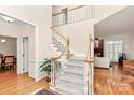 Bright foyer with hardwood floors, a staircase, and an open view into other rooms at 9800 Deer Brook Ln, Charlotte, NC 28210