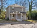 Charming two-story home with gray siding, a covered front porch, and a well-maintained lawn at 105 S York St, Lancaster, SC 29720