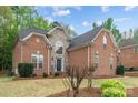 Charming two-story brick and stone home with well-manicured lawn and lush landscaping at 109 Stirling Heights Ln, Fort Mill, SC 29715