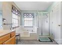 Bright bathroom with a large soaking tub and a separate glass-enclosed shower at 11834 Mallard Ridge Dr, Charlotte, NC 28269