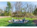 Inviting backyard boasts a fire pit with swing chairs, perfect for outdoor relaxation and entertainment at 1310 Seneca Pl, Charlotte, NC 28209