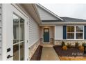 Welcoming front entrance with a teal-colored door and complementary landscaping at 143 Commerce Blvd, Lancaster, SC 29720