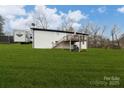 Spacious backyard with green grass and a wooden deck accessible by stairs at 17154 Frog Pond Rd, Oakboro, NC 28129