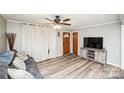 Cozy living room featuring wood floors, a ceiling fan, and a comfortable couch at 17154 Frog Pond Rd, Oakboro, NC 28129