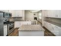 Modern kitchen featuring granite countertops, stainless steel appliances, a kitchen island, and ample cabinet space at 176 Cherry Birch St, Mooresville, NC 28117