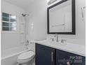 Bright bathroom featuring modern fixtures, a shower-tub combo, and a navy blue vanity at 1826 Taylor Ave, Charlotte, NC 28216