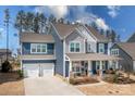 Charming two-story home with a spacious front porch, blue siding, and a two-car garage at 2024 Linn Cv, Waxhaw, NC 28173