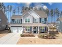 Charming two-story home with a welcoming front porch, a two-car garage, and well-manicured landscaping at 2024 Linn Cv, Waxhaw, NC 28173