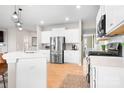 Modern kitchen with white cabinets, stainless steel appliances, a central island, and hardwood floors at 2024 Linn Cv, Waxhaw, NC 28173
