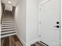 Bright hallway featuring staircase with hardwood treads, and a white paneled entry door at 2132 Electric Ln, Charlotte, NC 28205
