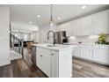 Modern white kitchen features an island with seating, stainless steel appliances, and open access to other spaces at 2132 Electric Ln, Charlotte, NC 28205