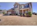 Charming two-story home with stone and brick exterior, landscaped yard, and attached two-car garage at 2598 Bryant Dr, Fort Mill, SC 29707