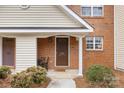 Close-up of a well-maintained front door with brick and siding, enhanced by stylish landscaping and a welcoming entrance at 3643 Melrose Cottage Dr, Matthews, NC 28105
