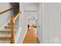 Inviting hallway with hardwood floors and staircase, showcasing a view into the living area for an open feel at 3643 Melrose Cottage Dr, Matthews, NC 28105