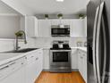 Bright kitchen featuring white cabinets, stainless steel appliances, and hardwood floors, blending style and functionality at 3643 Melrose Cottage Dr, Matthews, NC 28105