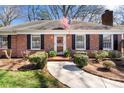 Close up of a red brick home with a well landscaped walkway leading up to the front door at 4425 Longwood Dr, Charlotte, NC 28209