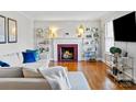 Cozy living room featuring a fireplace, bookshelves and a comfortable sectional sofa at 4425 Longwood Dr, Charlotte, NC 28209