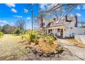 Side view of a charming white two-story home, featuring a front porch and beautifully landscaped yard at 4928 Tuckaseegee Rd, Charlotte, NC 28208