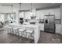 Modern kitchen featuring white cabinets, stainless steel appliances, large island with quartz countertops and barstool seating at 5049 Grain Orchard Rd # 3027B, Indian Trail, NC 28079