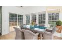 Bright breakfast nook with large windows, glass top table, and seating for six at 5672 Wrenfield Ct, Charlotte, NC 28277