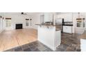 Open concept living space showing the kitchen with white cabinets and stainless steel appliances and hardwood floors at 5672 Wrenfield Ct, Charlotte, NC 28277