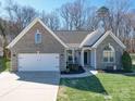Charming single-story brick home featuring an attached garage and a well-manicured front lawn at 572 Church St, Locust, NC 28097