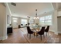Elegant dining room featuring a glass table, modern chandelier, and natural light from large windows at 574 Reid St, Belmont, NC 28012