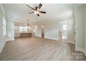 Spacious open-concept living room with wood floors, a ceiling fan, and seamless flow to the modern kitchen at 574 Reid St, Belmont, NC 28012