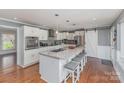 Open concept kitchen features stainless steel appliances, a granite island with seating, and a sliding barn door at 748 Saint Cloud Dr, Statesville, NC 28625
