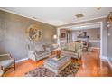 Open concept dining room with hardwood flooring, elegant chandelier, and views of the living room at 8134 Chatham Oaks Dr, Concord, NC 28027