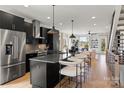 Modern kitchen with black cabinetry, stainless steel appliances, large center island, and open concept living space at 904 Van Every St, Charlotte, NC 28205