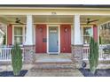 Inviting front porch with detailed columns, ceiling fans, and fresh landscaping at 106 Orange St, Charlotte, NC 28205